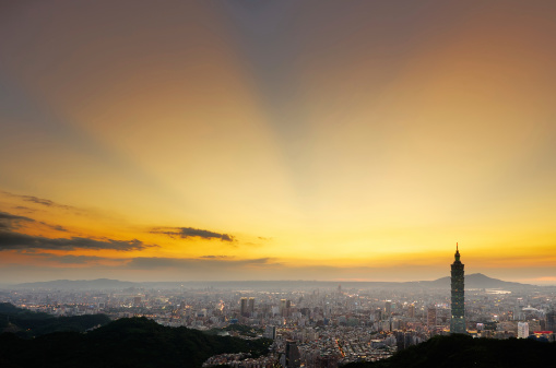 Dramatic urban cityscape of Taipei with famous landmark, 101 skyscraper under amazing sunbeam light in sunset in Taiwan, Asia.