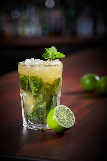 Glass of mojito with half a lime on a wooden table stock photo