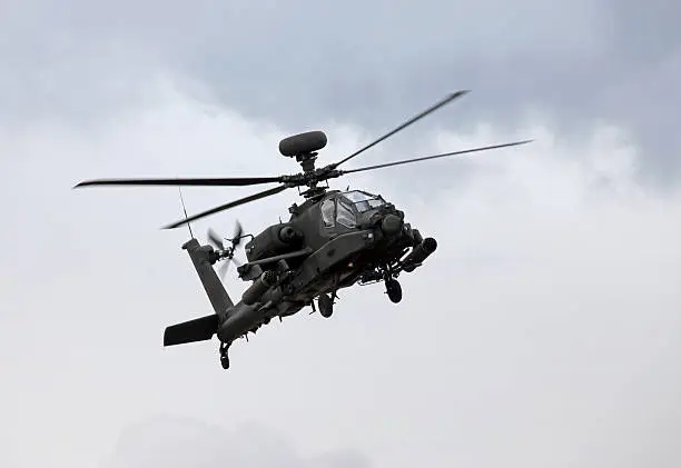 An Apache gunship approaches an airfield for a landing
