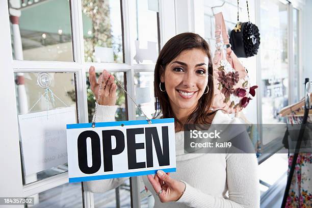 Photo libre de droit de Femme Hispanique En Boutique Avec Un Panneau Ouvert banque d'images et plus d'images libres de droit de Femmes