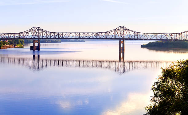 Cantilever bridge across Illinois river "Early morning picture of the Illinois River at Peoria, Illinois. Local bridge in the background." illinois nature stock pictures, royalty-free photos & images