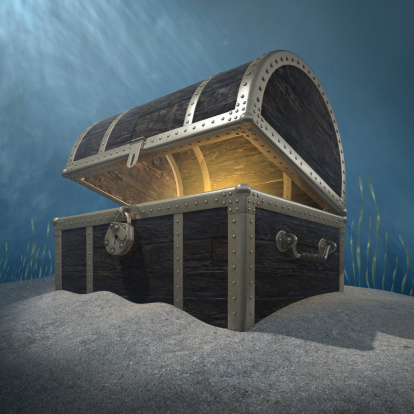 Three quarter view of a open treasure chest with a golden glow emanating from inside on a underwater background.Could symbolize a prize of great value.This is a detailed 3d rendering.