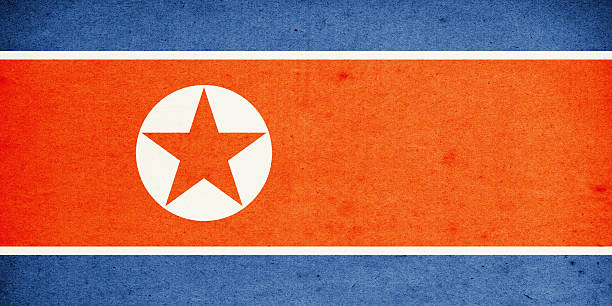 Close-up on a paper flag of North Korea with light effect and vignette. Visible paper texture for super realistic effect. Selective focus. Canon 5D Mark II and Sigma lens.SEE MORE STATE FLAGS BELOW: