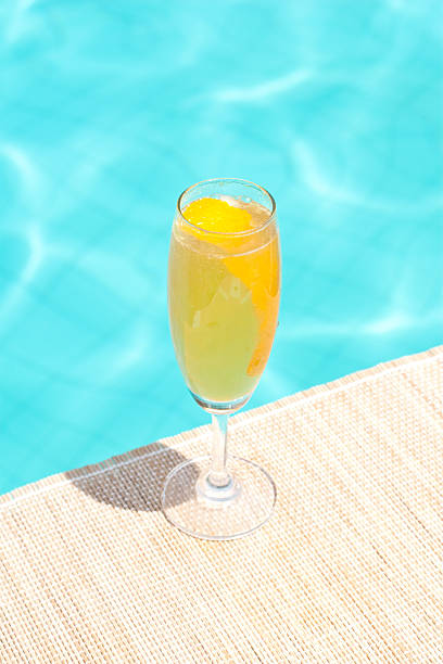 Mimosa classic cocktail near waterpool on the mat stock photo