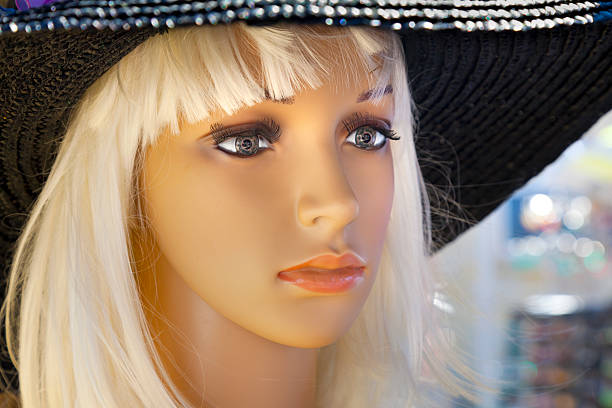 Mannequin heads in knitted hats and scarves. Mannequins female heads in hats and scarfs close up. Woolen knitted caps and scarves. Female headdresses