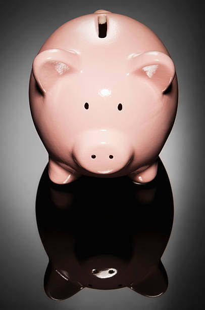istock Pink ceramic piggy bank isolated on black background 184358085