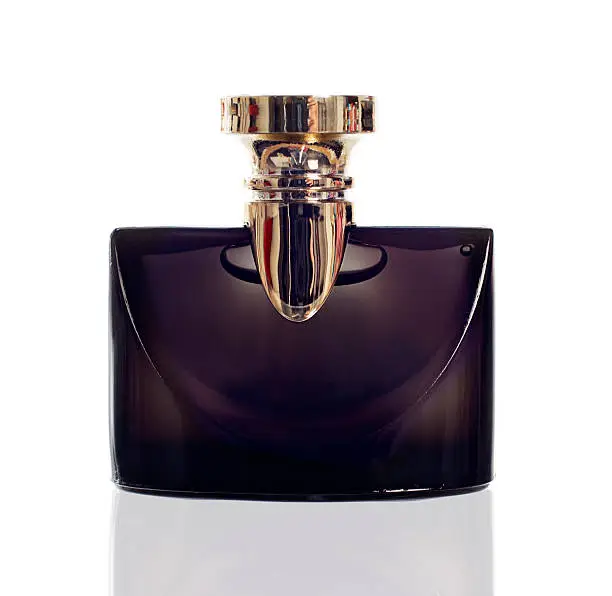 Photo of Black glass perfume bottle with gold lid on white