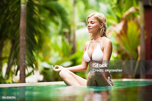 Mujer Joven Meditando Rodeado De Plantas Exóticas Foto de stock y más banco de imágenes de Fémina - Fémina, Mujeres, Piscina