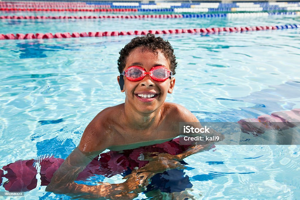 Boy in swimming pool Boy in swimming pool, hanging on lane rope, 10 years. Swimming Stock Photo