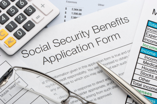 Close up of social security application with calculator and pen