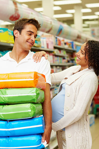 ご出産を控えたカップルのスーパーマーケットのおむつ購入 - diaper shopping human pregnancy supermarket ストックフォトと画像