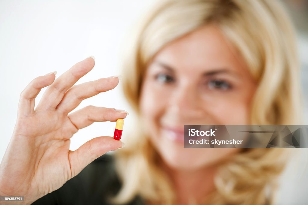 Bella bionda donna con una pillola. - Foto stock royalty-free di Adulto
