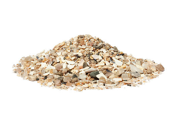 Beach sand isolated on white "Close-up of a small mound of beach gravel and coarse sand, mainly quartz and shell fragments; isolated on white. There are companion images of builders sand and soft beach sand." gravel mound stock pictures, royalty-free photos & images
