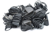 Old mobile phone chargers pile isolated on white