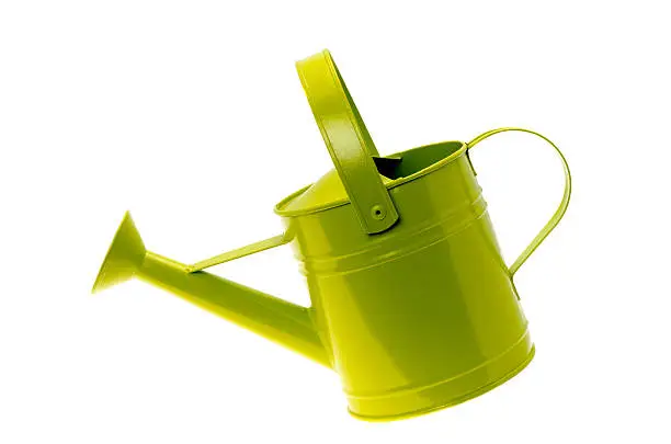 Tilted green coloured metal watering can isolated on a white background