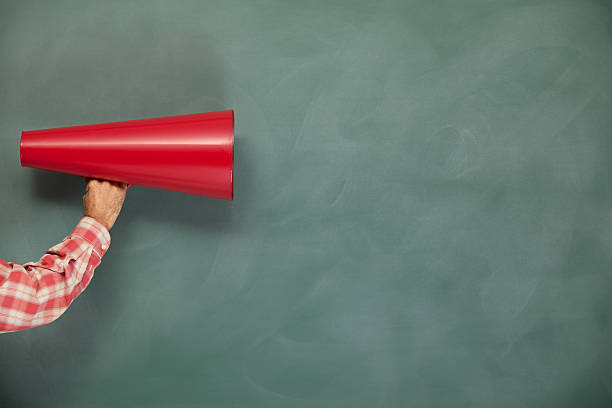 istock Red Megaphone In Human Hand On Green Blank Blackboard 184359492