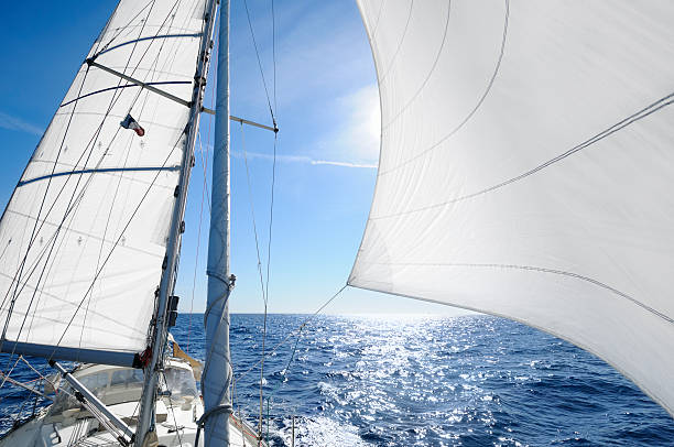 istock Sailing boat with the sun shingn behing sail 184359593