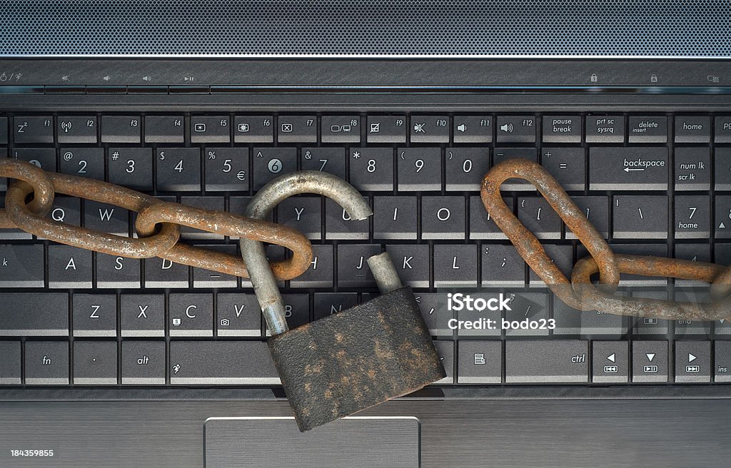 Burglary Cut old padlock with rusty chain on laptop keyboard Breaking Stock Photo