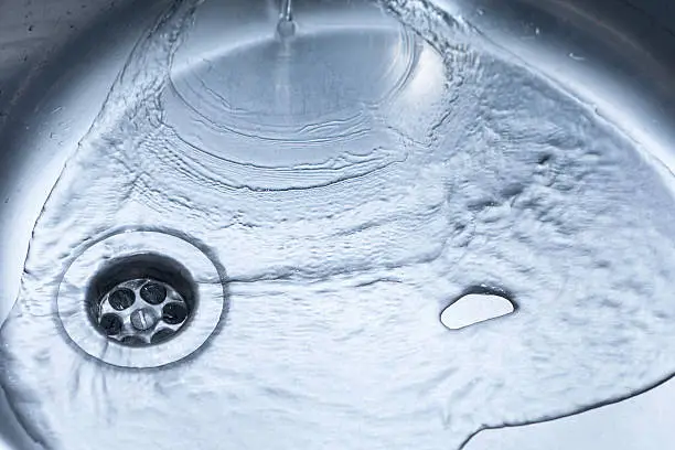 Close-up of kitchen sink with water running away