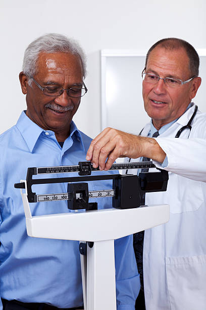 gewichtsabnahme - dieting weight scale doctor patient stock-fotos und bilder