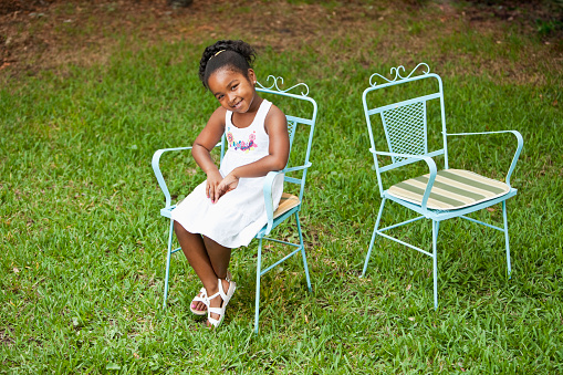 Cute little girl sitting in back yard.  7 years.