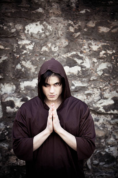 escuro monge com uma intensa olhar em oração. espaço para texto - bad habit imagens e fotografias de stock