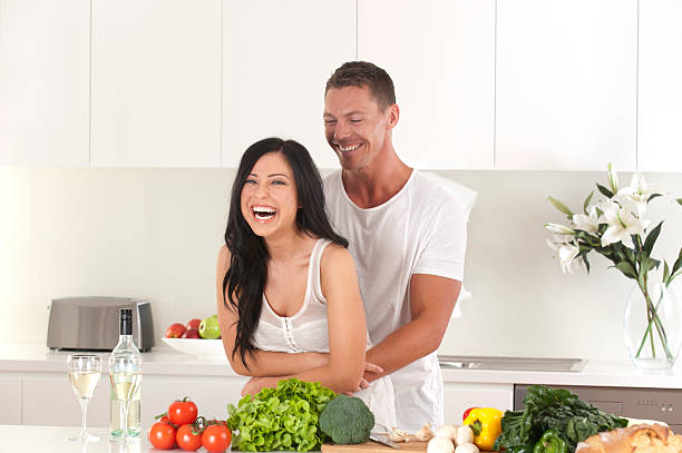 istock Couple embracing and laughing in the kitchen 184361103