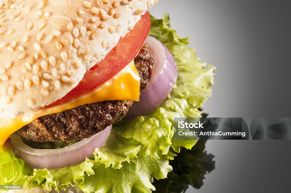 Cheeseburger with onion, tomato and lettuce isolated on black Gourmet Burger with cheese, onion, lettuce and tomato in a toasted sesame seed bun Barbecue - Meal Stock Photo