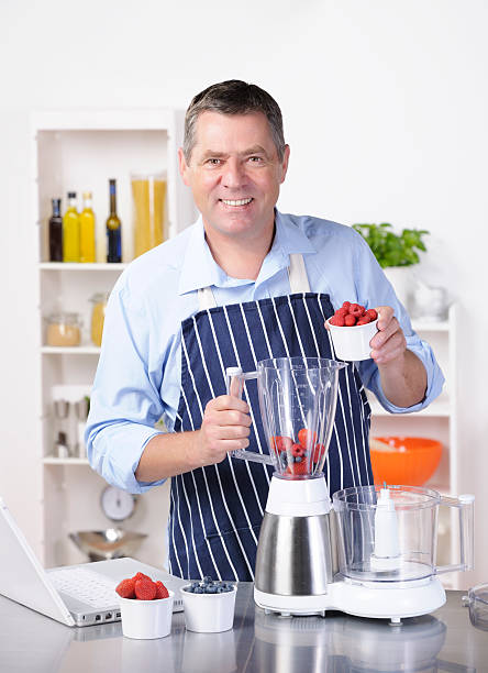 istock Mature Man Pouring Fruit Into Blender During Smoothie/ Dessert Making 184361297