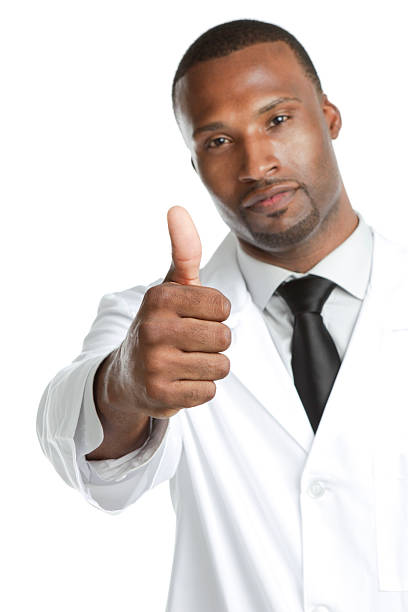 African ethnicity male wearing lab coat gesturing thumbs up "Serious man wearing lab coat giving the thumbs up, isolated on white background" yes single word stock pictures, royalty-free photos & images