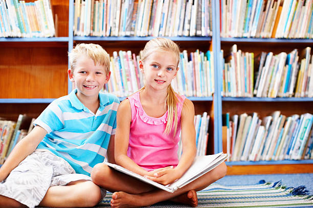 istock Cute children with book in the library 184361800