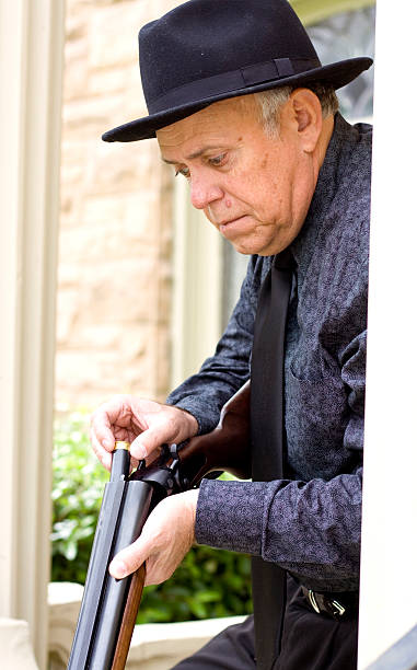 istock Crazy old man putting a shot gun shell in shotgun 184361988