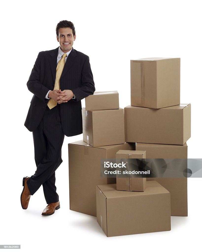Uomo d'affari appoggiato su alcune scatole - Foto stock royalty-free di Abbigliamento elegante