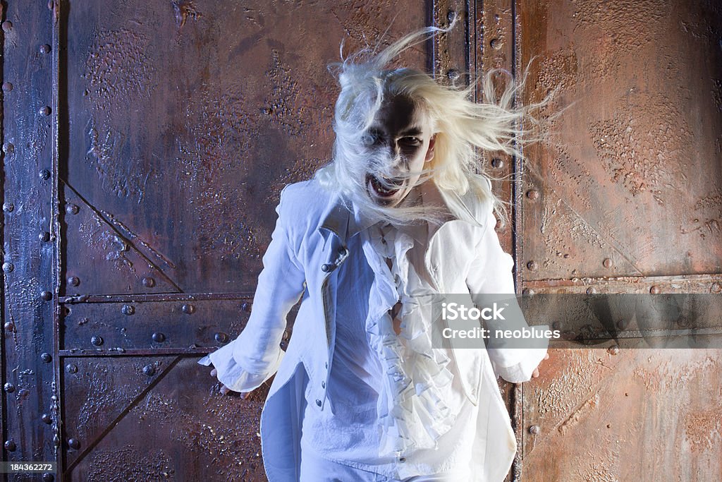 Vampire is screaming. "Vampire is screaming. He has white, long hair and a white suit. Over  grunge background. Halloween." Adult Stock Photo