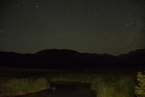 The night sky over a river in the Rocky Mountains