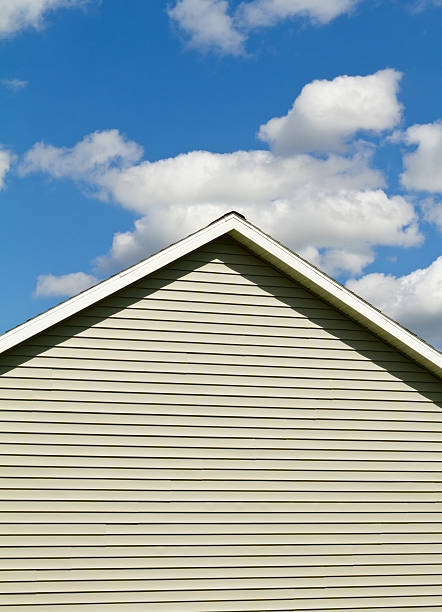 Close up of vinyl siding on a new home with blue sky in the background