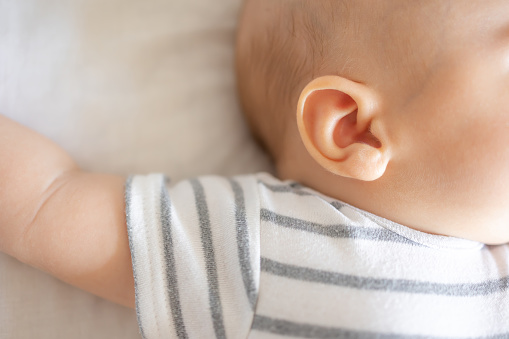 Newborn ear closeup, baby asleep natural colours