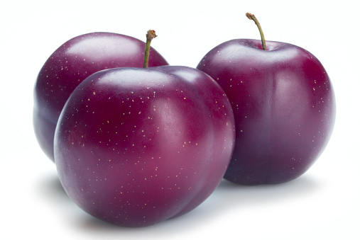 Three plums on white background