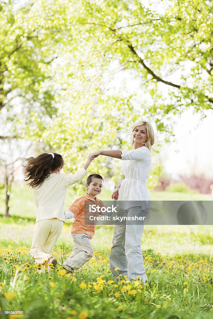 Madre, giocando con i suoi figli in un parco - Foto stock royalty-free di Bambino