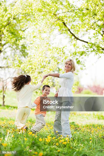 Madre Giocando Con I Suoi Figli In Un Parco - Fotografie stock e altre immagini di Bambino - Bambino, Madre, Cerchio