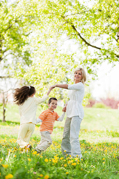 istock Mother playing with her children in a park 184363757