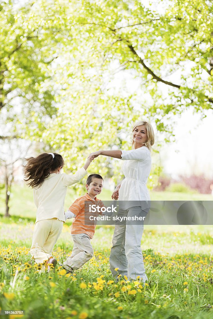 Mãe, brincando com seus filhos em um parque - Foto de stock de Criança royalty-free