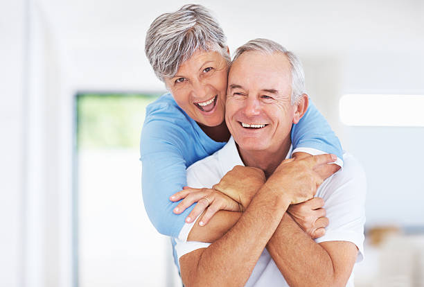 istock Happy senior couple embracing at home 184364026