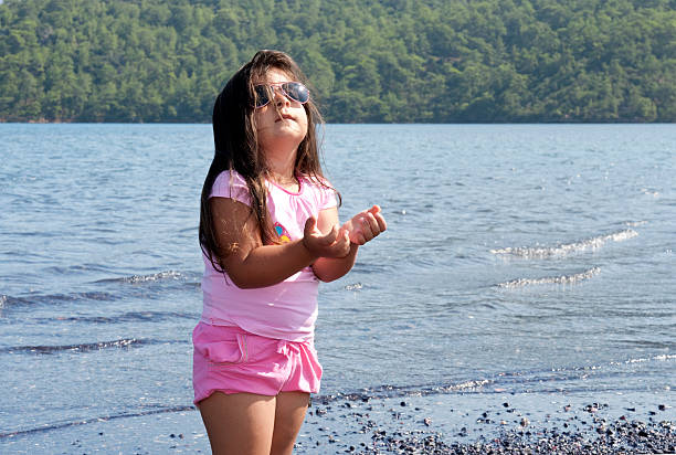 kleines mädchen beten - child praying beach little girls stock-fotos und bilder