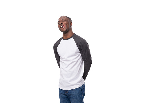 young african man with short haircut smiling cutely on studio background with copy space.