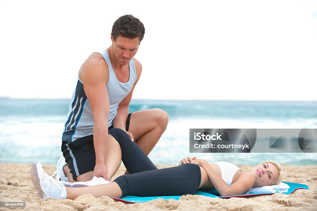 Woman receiving physical therapy Woman receiving physical therapy at the beach 20-29 Years Stock Photo