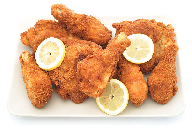 istock Homemade fried chicken legs on plate with lemons 184365290