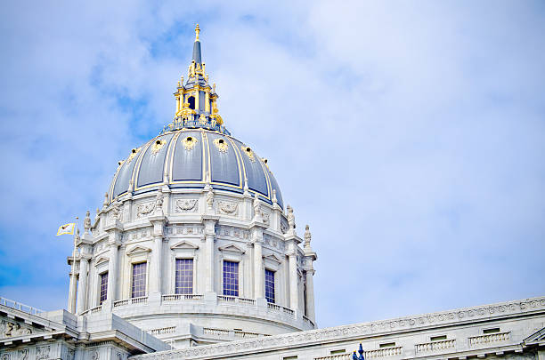 A Filipino couple in their 30s stand in City Center Plaza outside San Francisco City Hall and use their smart phones while enjoying a fun and relaxing winter staycation exploring the San Francisco Bay Area in California.