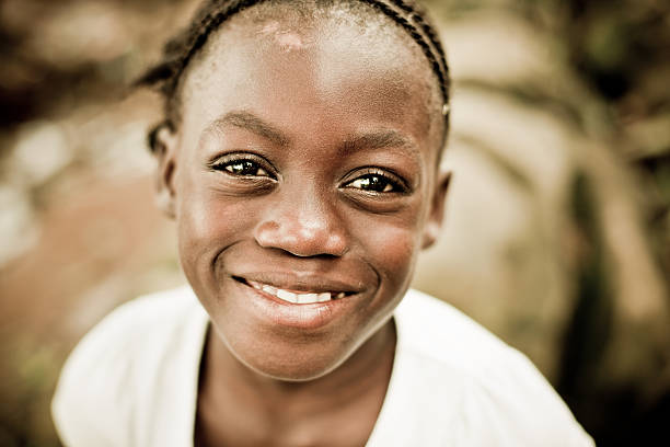 Close-up portrait of a smiling girl A young African girl smiling at the camera.  poverty child ethnic indigenous culture stock pictures, royalty-free photos & images