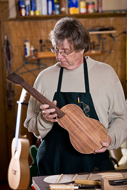 istock Craftsman in workshop holding unfinished ukulele 184365691